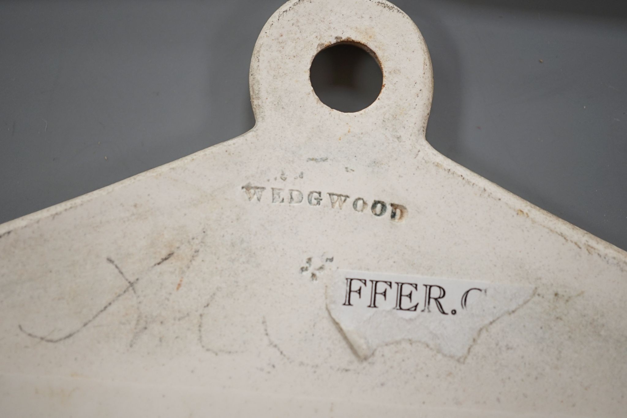 Three late 18th century creamware cellar labels, two claret stamped Wedgwood and one sherry, unmarked, 14 cms wide.